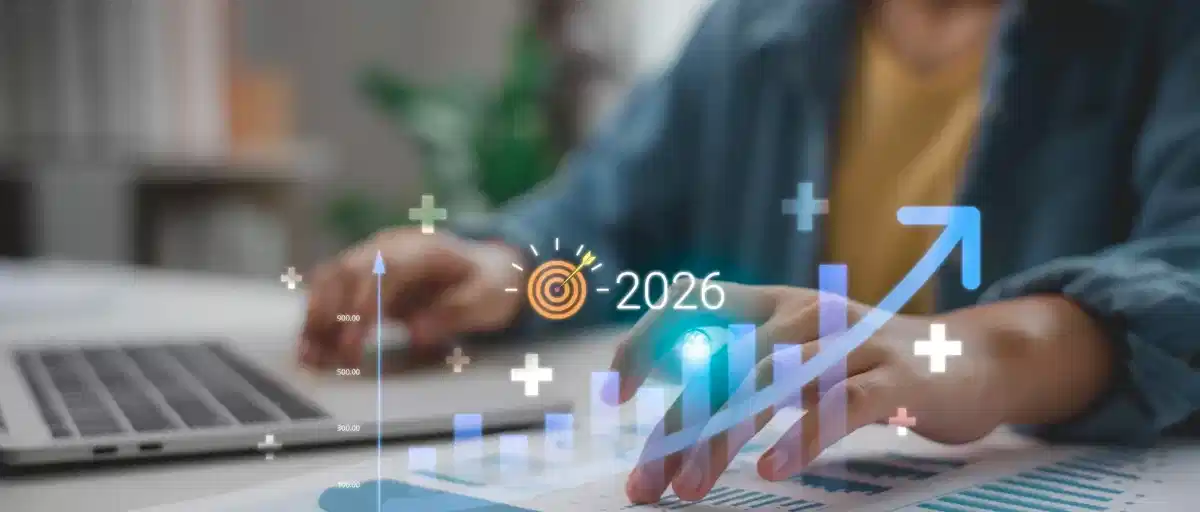 bilgisayar başındaki birinin elleri. 2026 yazısı ve bir artış grafiği